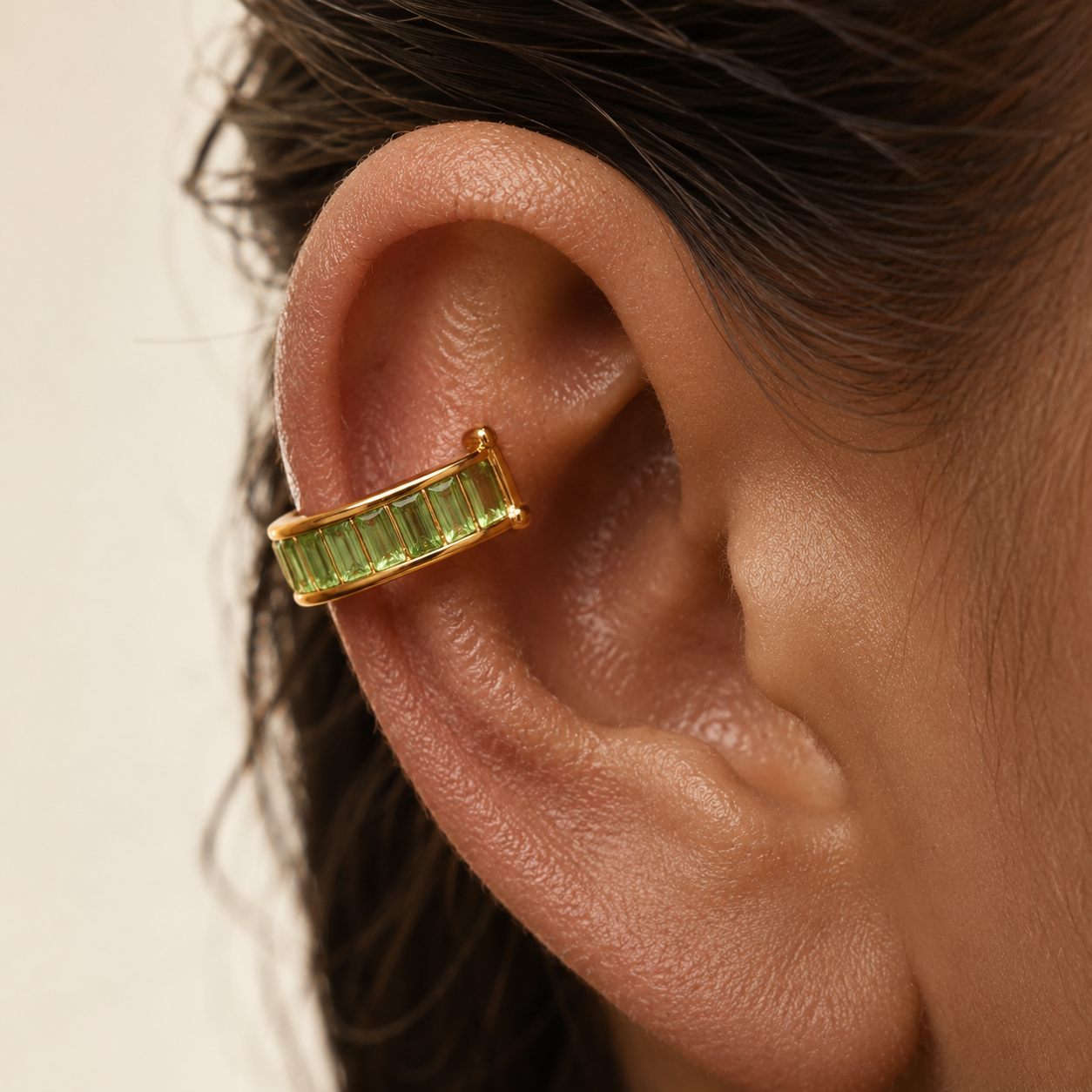 Close-up of a gold ear cuff clipped onto the upper cartilage, showing how the band curves and holds by tension. No piercing needed. Stays in place without a hole.