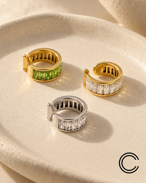 Baguette ear cuff in Jade, Gold and Silver finishes on a cream ceramic tray, channel-set baguette stones