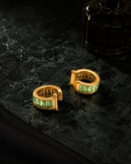 Jade Baguette ear cuffs styled on dark green marble with a perfume bottle