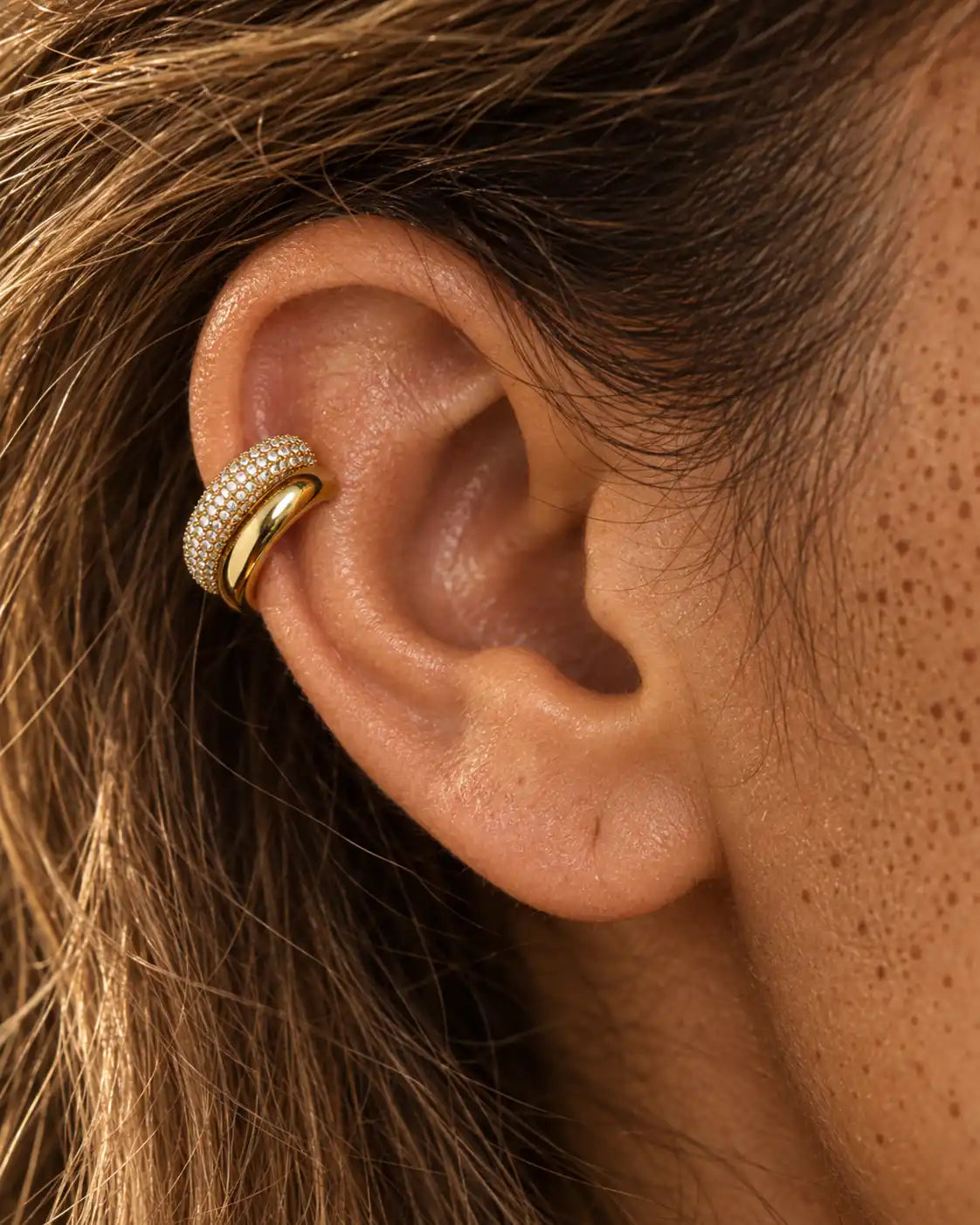 Gold Pave Dome ear cuff seen close on the ear, the double band following the curve of the cartilage. No piercing needed.