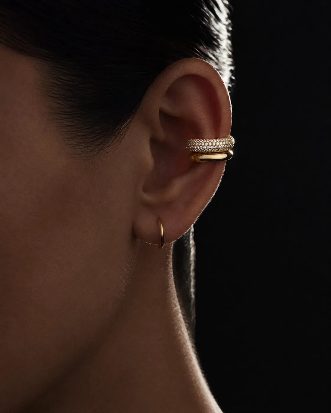 Gold pave dome ear cuff worn on the helix with a gold hoop on the lobe, no piercing needed