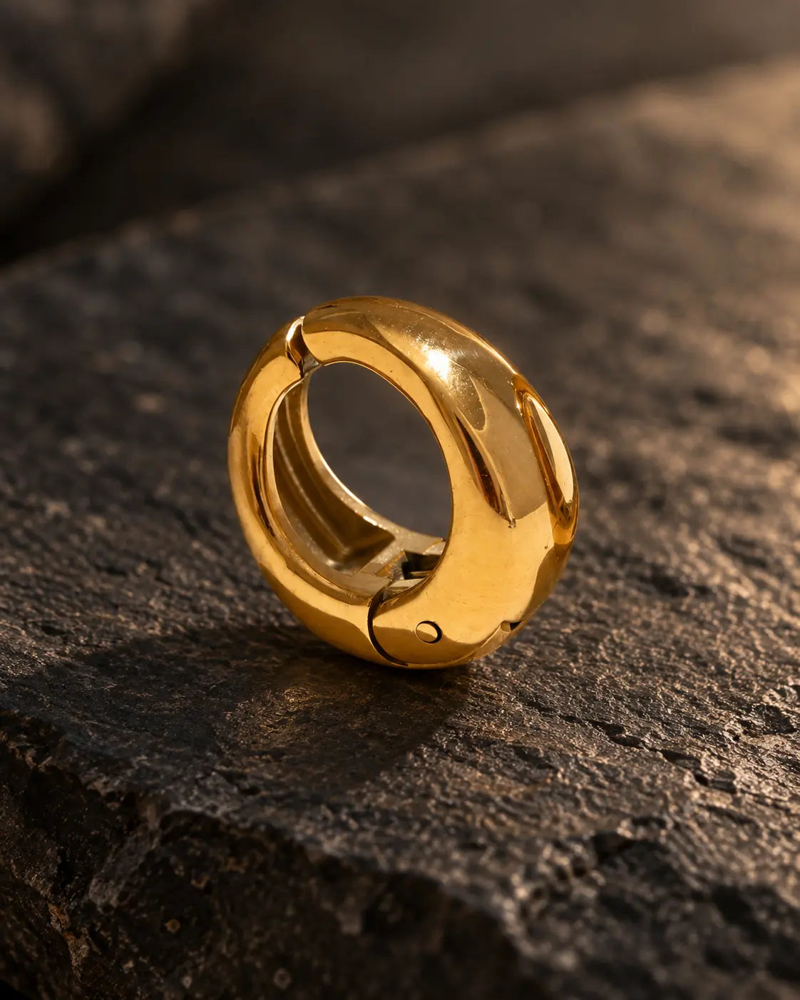 Close-up of the Gold Ridge clip-on hoop showing the hinged closure and the thickness of the dome. PVD real gold plated stainless steel.