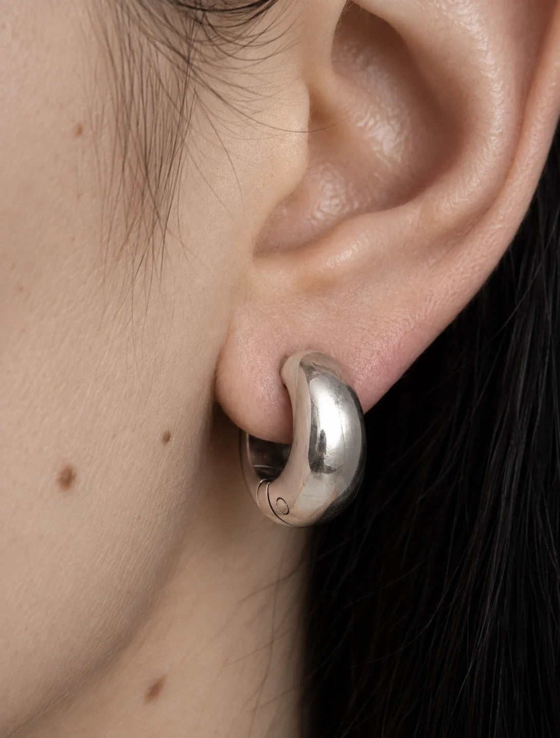 Silver Ridge clip-on hoop seen close on the lobe, showing how the hoop anchors without a piercing.