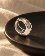 Close-up of the Silver Ridge clip-on hoop, polished chunky dome with hinged click closure. Platinum plated stainless steel.