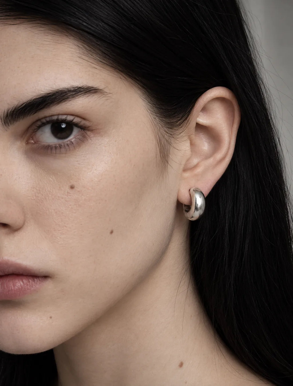 Silver Ridge clip-on hoop worn on the lobe, thick polished hoop sitting firm. No piercing needed. Platinum plated stainless steel.
