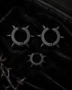 Matte black spike cuff set, three pieces, styled on black velvet with thorn branch